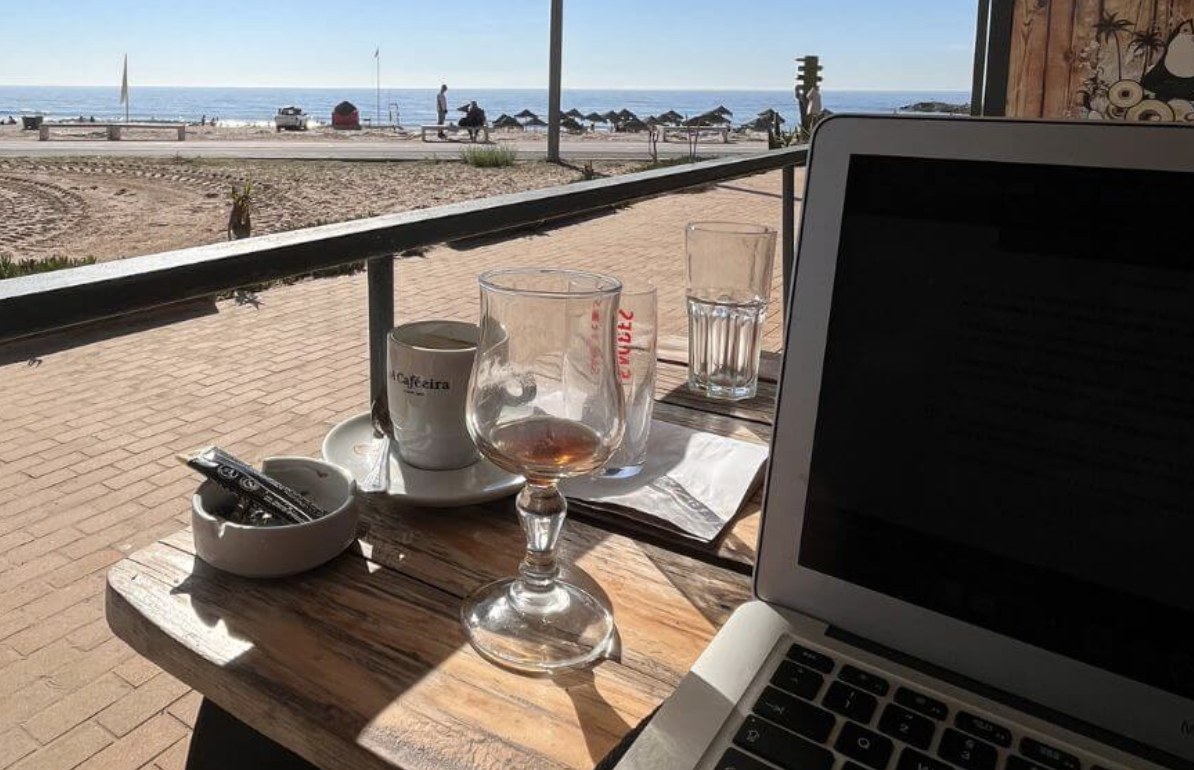 Notebook, pen, and glass of water on an office desk overlooking the city, representing executive career coaching